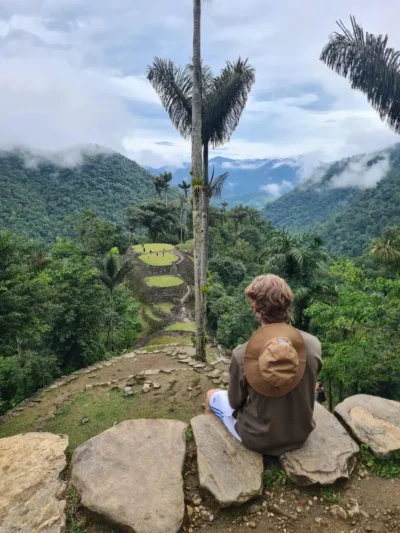 Experiencia ciudad perdida 4 días con guía indígena Turista disfrutando de la vista a las terrazas de la Ciudad Perdida rodeado de vegetación