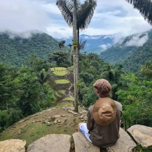 Turista disfrutando de la vista a las terrazas de la Ciudad Perdida rodeado de vegetación
