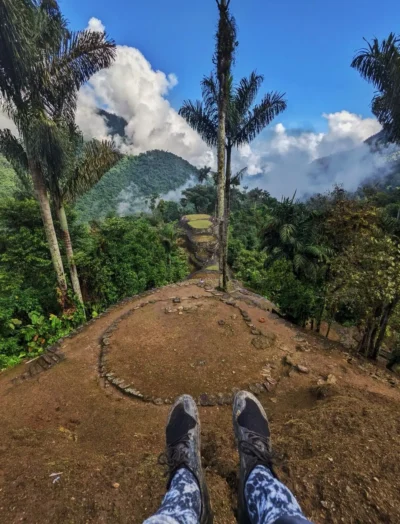 Turista sentado en una de las terrazas de la Ciudad Perdida disfrutando de las vistas y el entorno natural